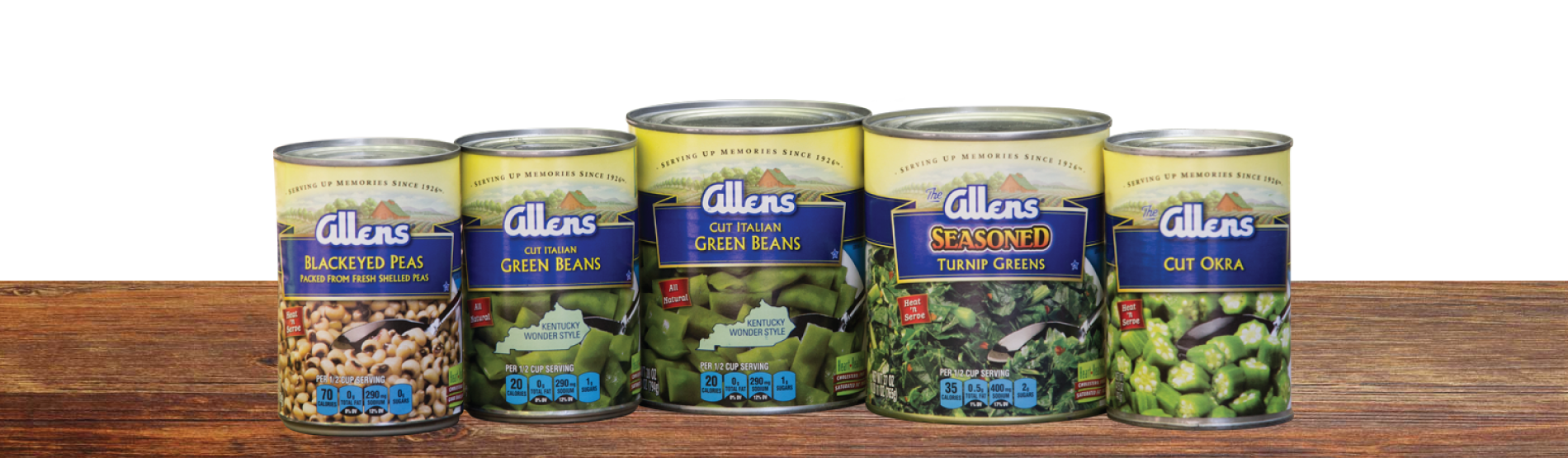 Cans of Allens Vegetables Lined up on a Wood Table